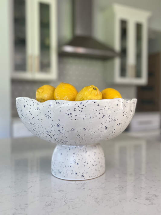 Speckled ceramic bowl with lemons on a kitchen counter